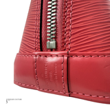 Close-up of a red Louis Vuitton handbag with a zipper on a white background