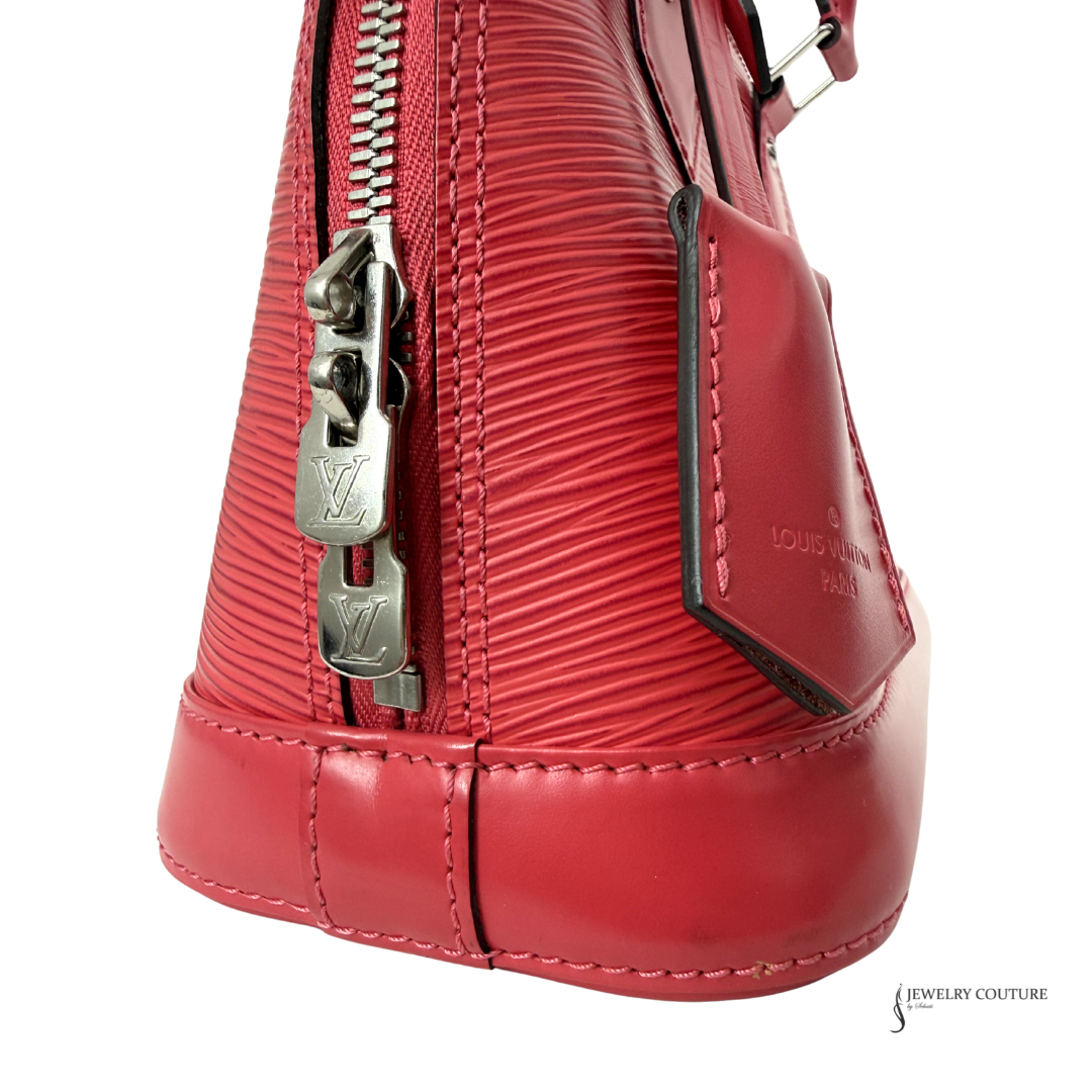 Close-up of a red handbag with a silver zipper on a white background