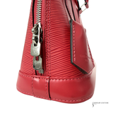 Close-up of a red handbag with a silver zipper on a white background