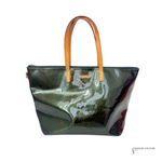 Green handbag with brown handle on a white background