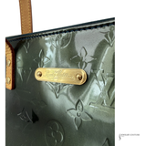 Louis Vuitton handbag with gold logo plate on a white background