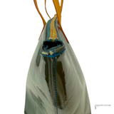 Glass sculpture with blue and yellow threads on a white background
