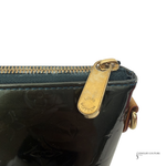 Close-up of a Louis Vuitton handbag with a gold zipper tab on a white background.