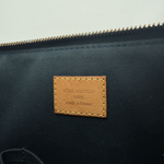 Louis Vuitton bag with a brown leather label on a light gray background