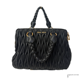 Black quilted MIU MIU  handbag with braided handle on a white background