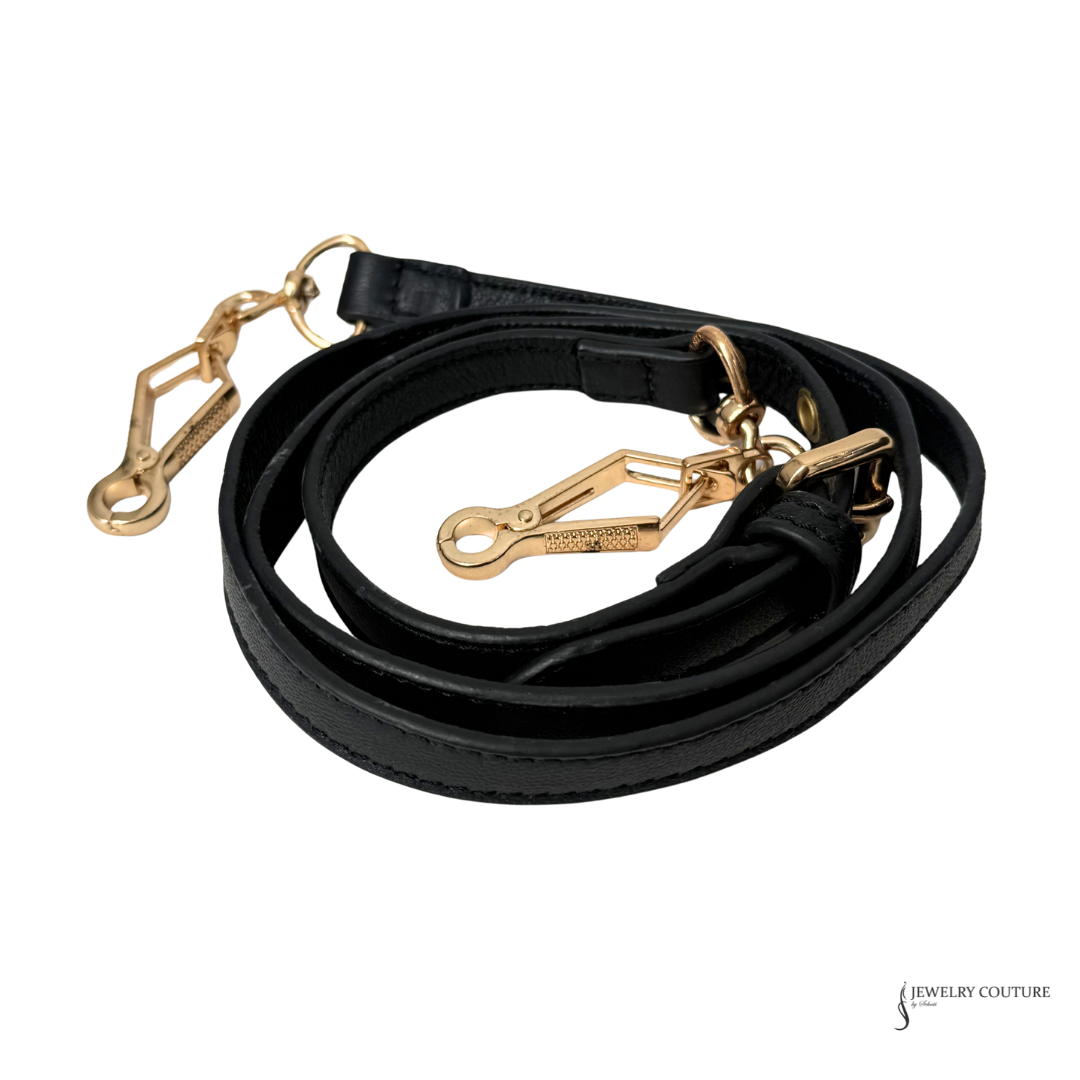 Black leather dog leash with gold hardware on a white background