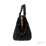 Black textured handbag with braided handle on a white background