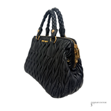 Black textured handbag with braided handles on a white background