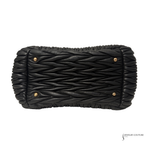 Black woven clutch bag with gold accents on a white background