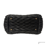Black woven clutch bag with gold accents on a white background