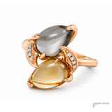 Rose gold ring with two gemstones on a white background