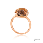 Rose gold ring with a large brown gemstone and smaller diamonds on a white background