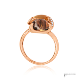 Rose gold ring with a large brown gemstone and smaller diamonds on a white background