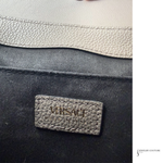 Versace label on a black and gray leather product