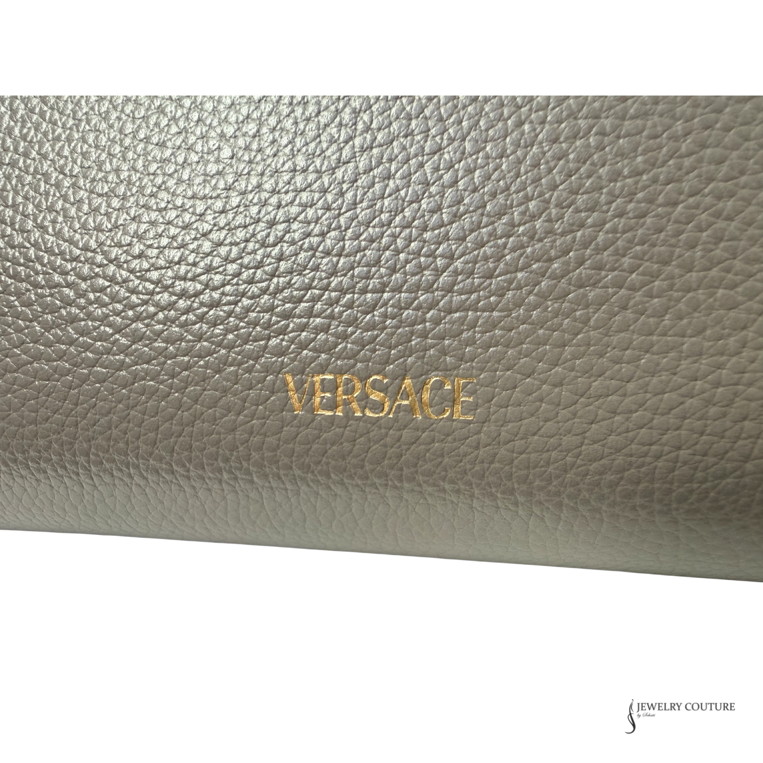 Close-up of a Versace wallet with gold lettering on a light gray background