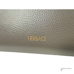 Close-up of a Versace wallet with gold lettering on a light gray background