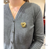 18K gold love knot brooch worn on a cardigan, showing size on the model