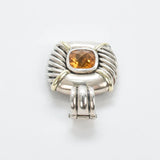 A sterling silver and yellow gold ring featuring a cushion-cut orange citrine gemstone, photographed on a clean white background.