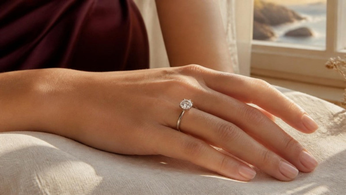 Diamond engagement ring on a hand in warm light
