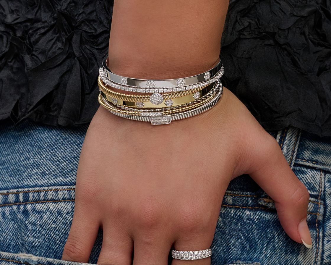 Simon G diamond and gold bangle bracelets stacked on the wrist with a diamond band