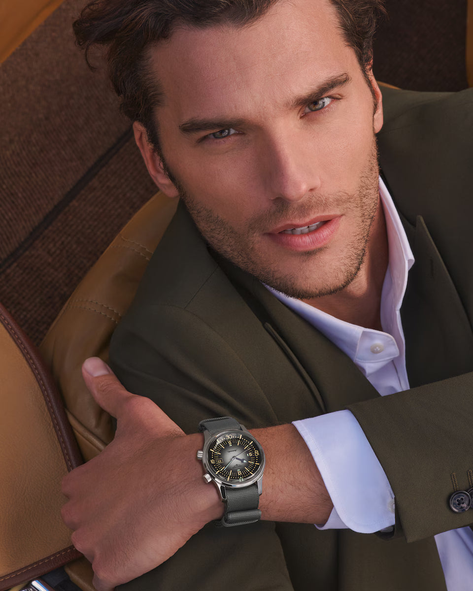 Man wearing a watch, sitting in a car interior.