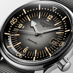 Longines watch with black dial and silver case on a light gray background