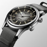 Longines watch with black face and mesh band on a light gray background