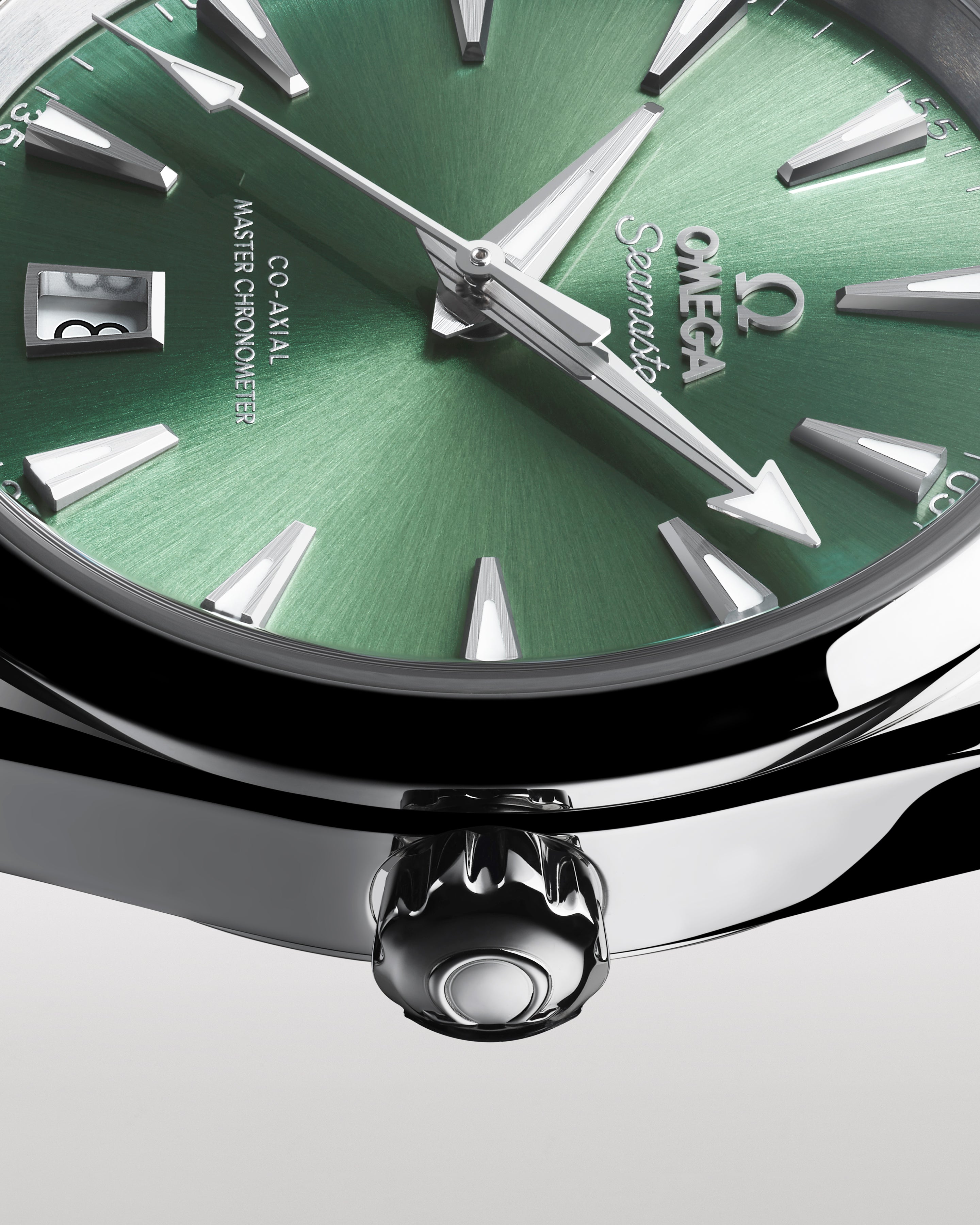 Close-up of a green Omega watch face with silver accents on a white background