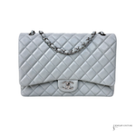 Light blue grayish quilted handbag with silver chain and CC logo on a white background