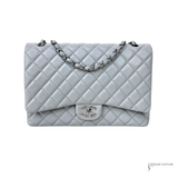 Light blue grayish quilted handbag with silver chain and CC logo on a white background