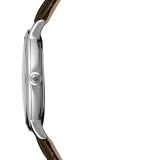 A side profile view of a wristwatch with a polished silver-tone case and a dark brown textured strap, shown against a plain white background.