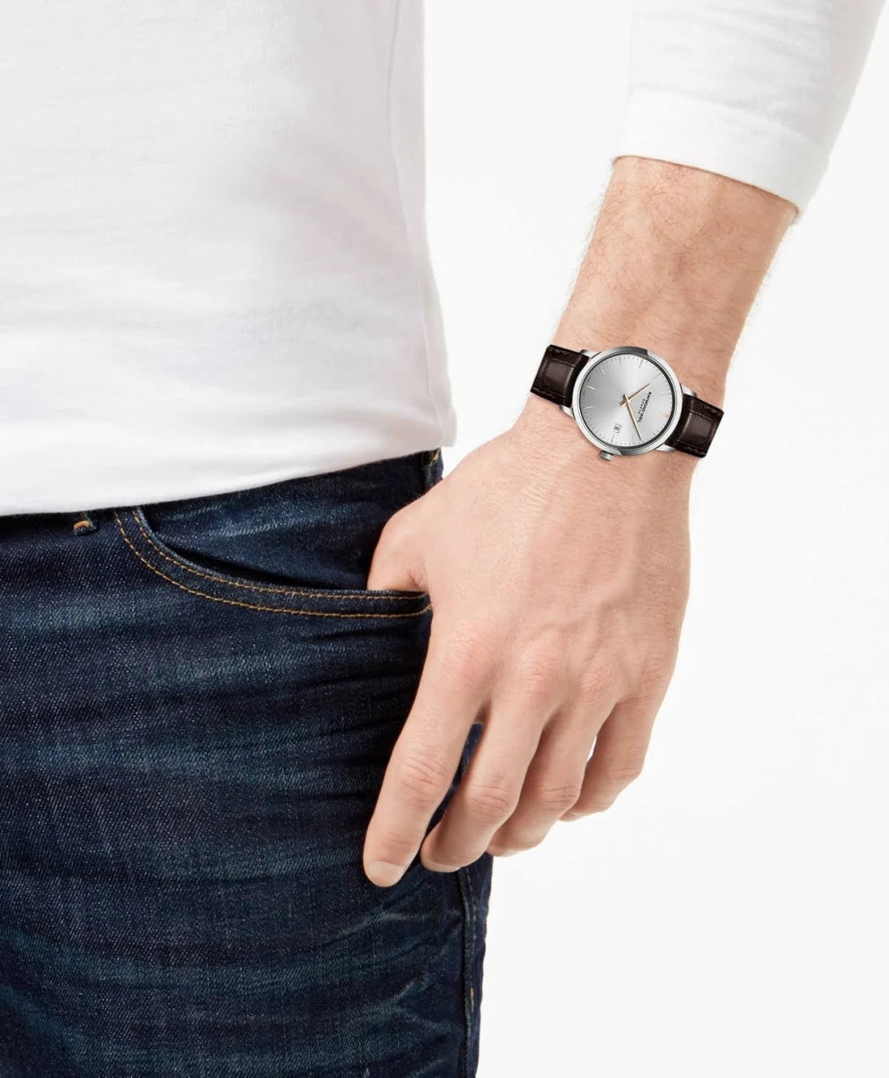 Person wearing a watch with a brown strap on a plain background