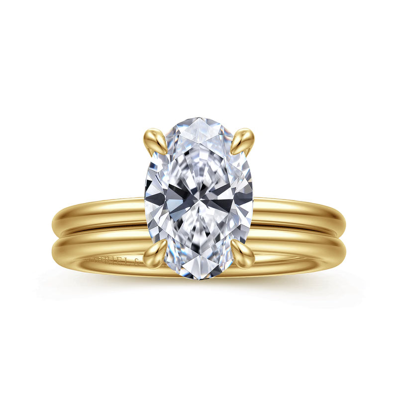 A yellow gold ring with a large oval-cut clear gemstone in a four-prong setting, shown on a plain white background.