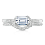 Diamond ring with a central emerald-cut gemstone and diamond-studded band on a white background