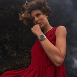 Woman in a red dress with a dark, textured background