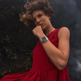 Woman in a red dress with a dark, textured background